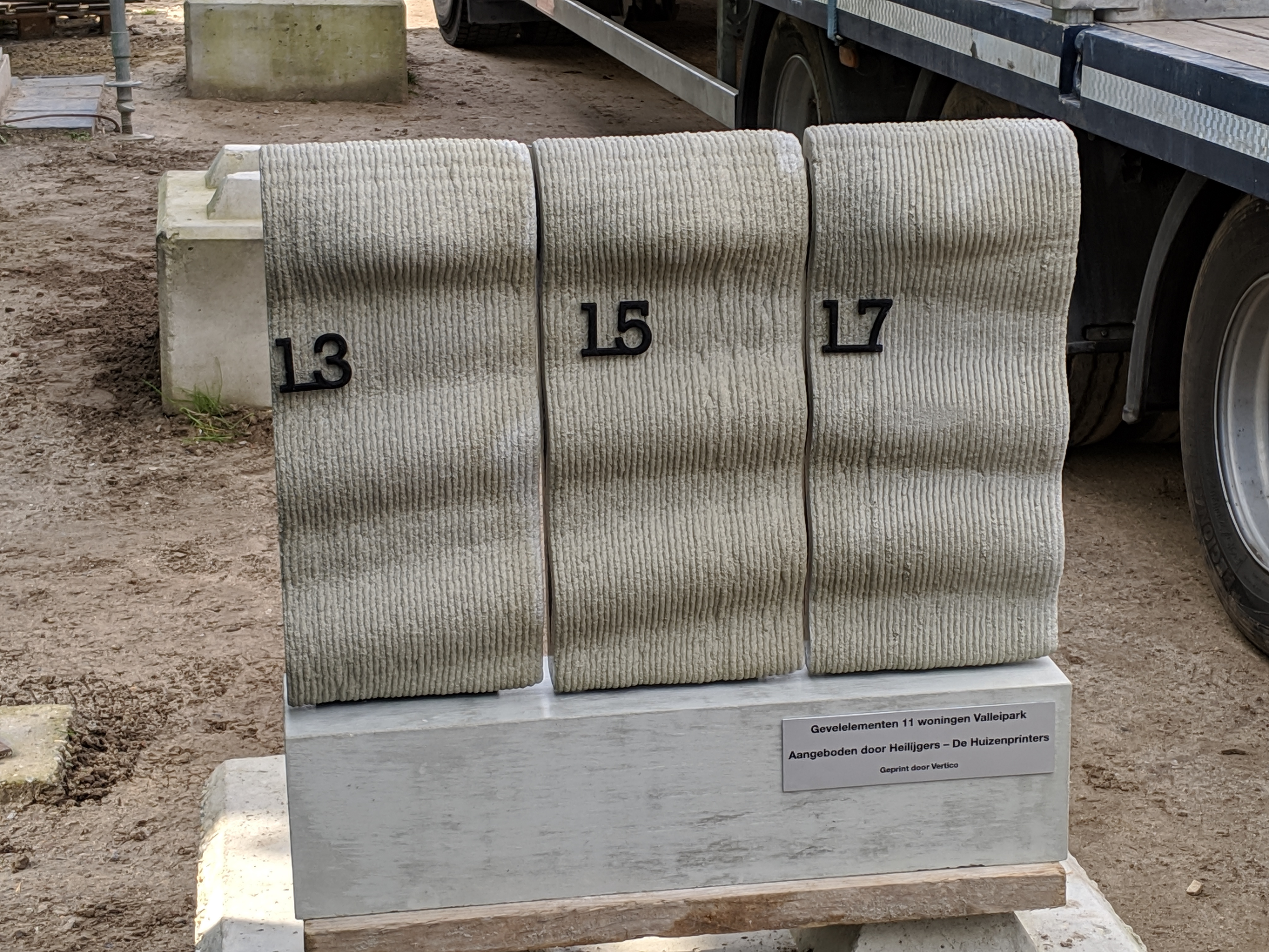 Completed concrete panels numbered 13, 15, and 17 displayed together at the construction site