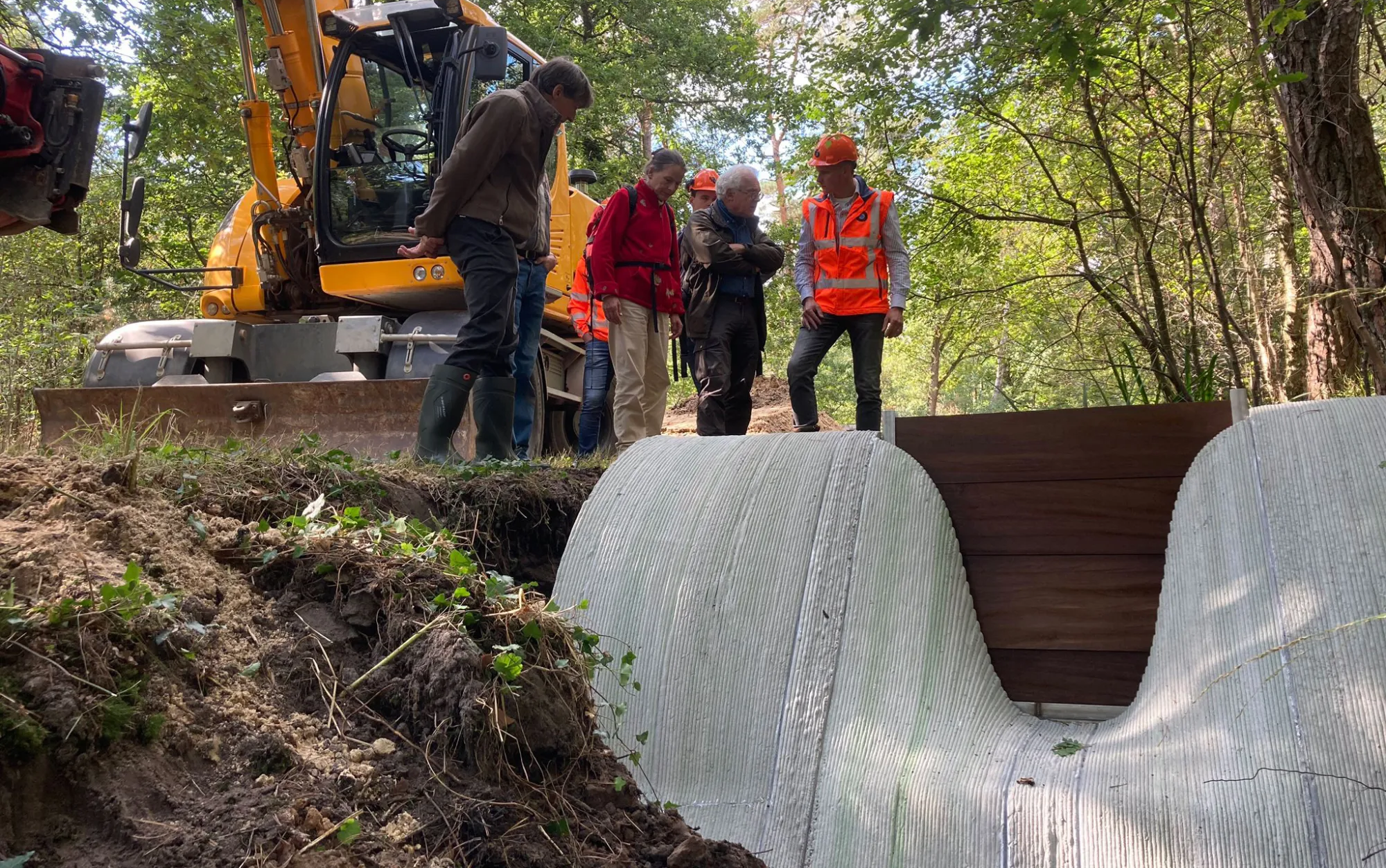 The concrete dam installed in the riverbed while the project team inspects the site