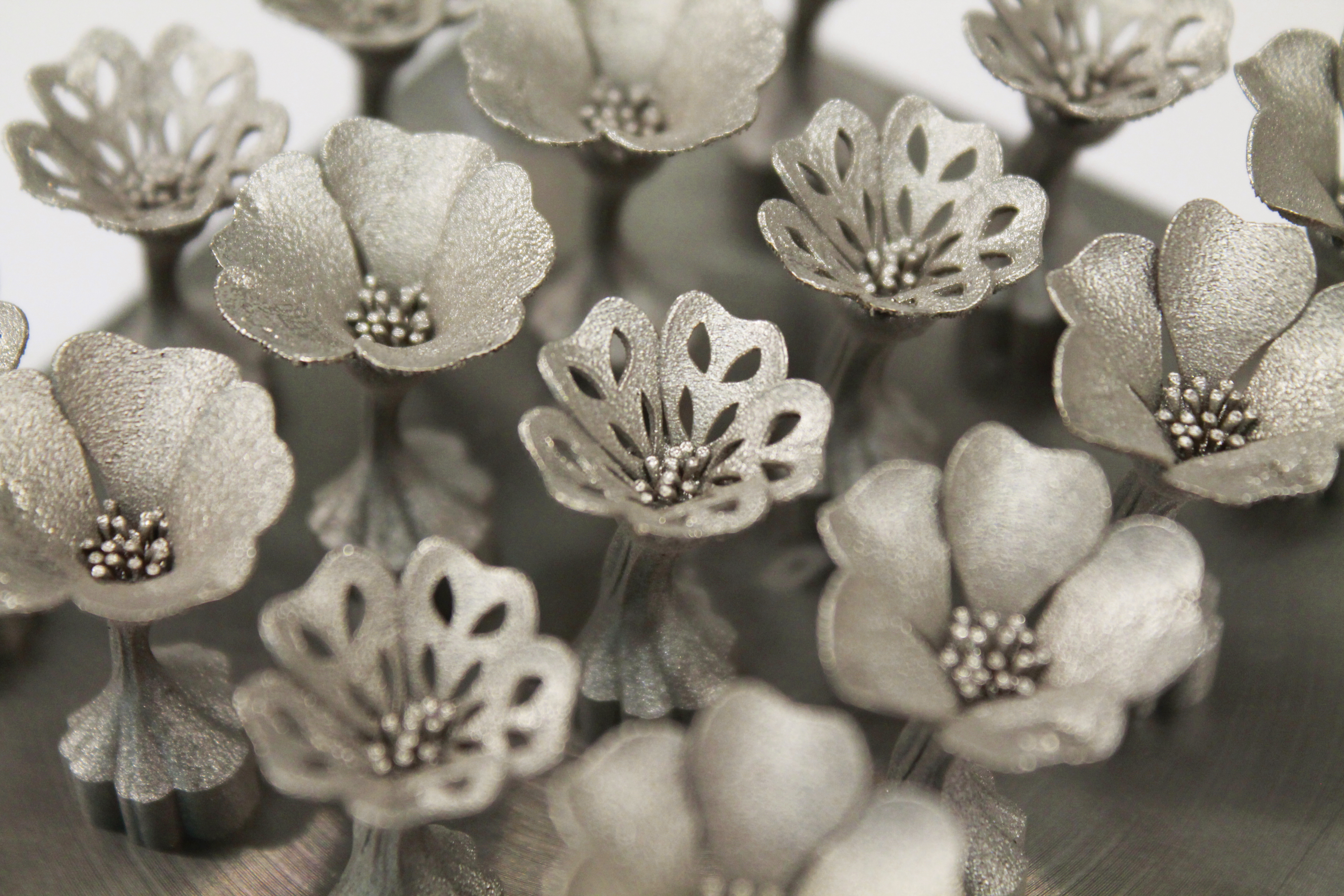 Close-up of solid and open geranium flower cufflinks on the print bed
