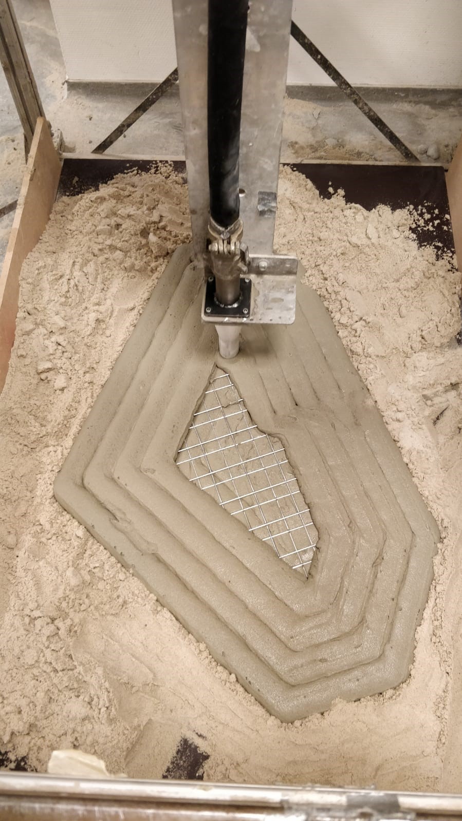 Concrete extruder printing a polygonal block in layers