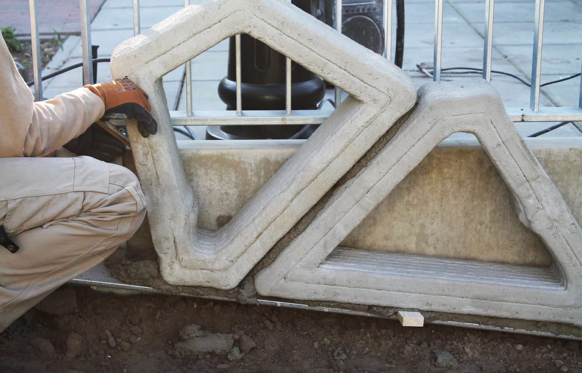 A 3D-printed concrete facade element being handled during assembly