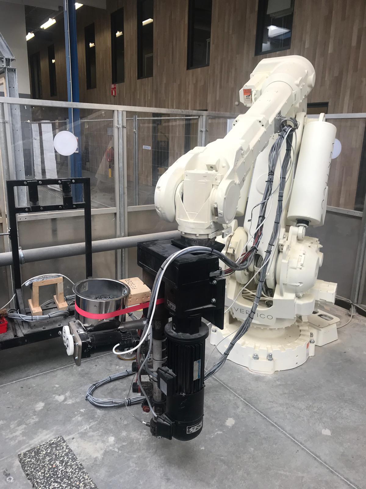 Industrial robot arm fitted with a printing extruder in the fabrication workshop