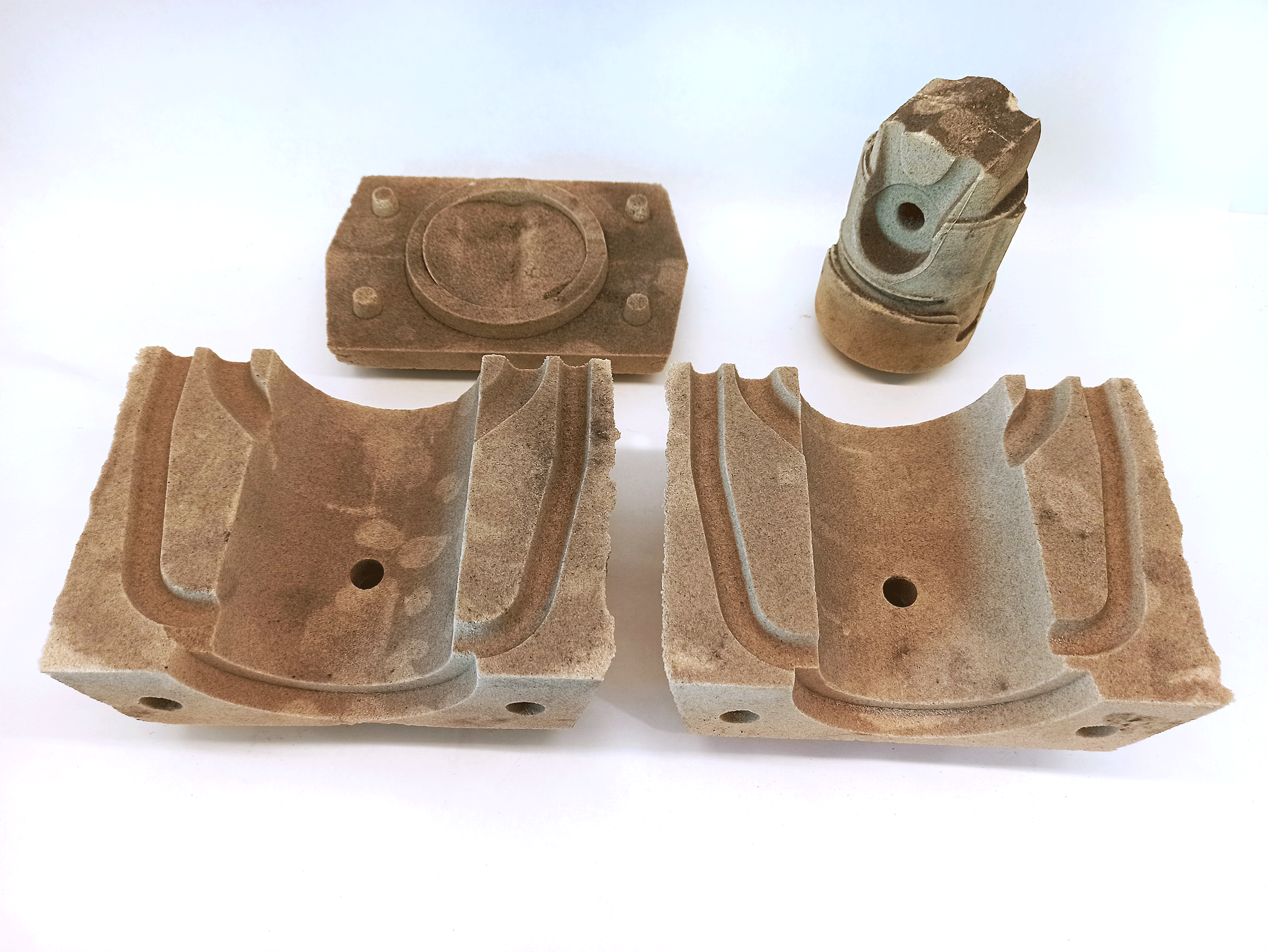 Two sand mould halves, a top plate, and a core used to form the piston