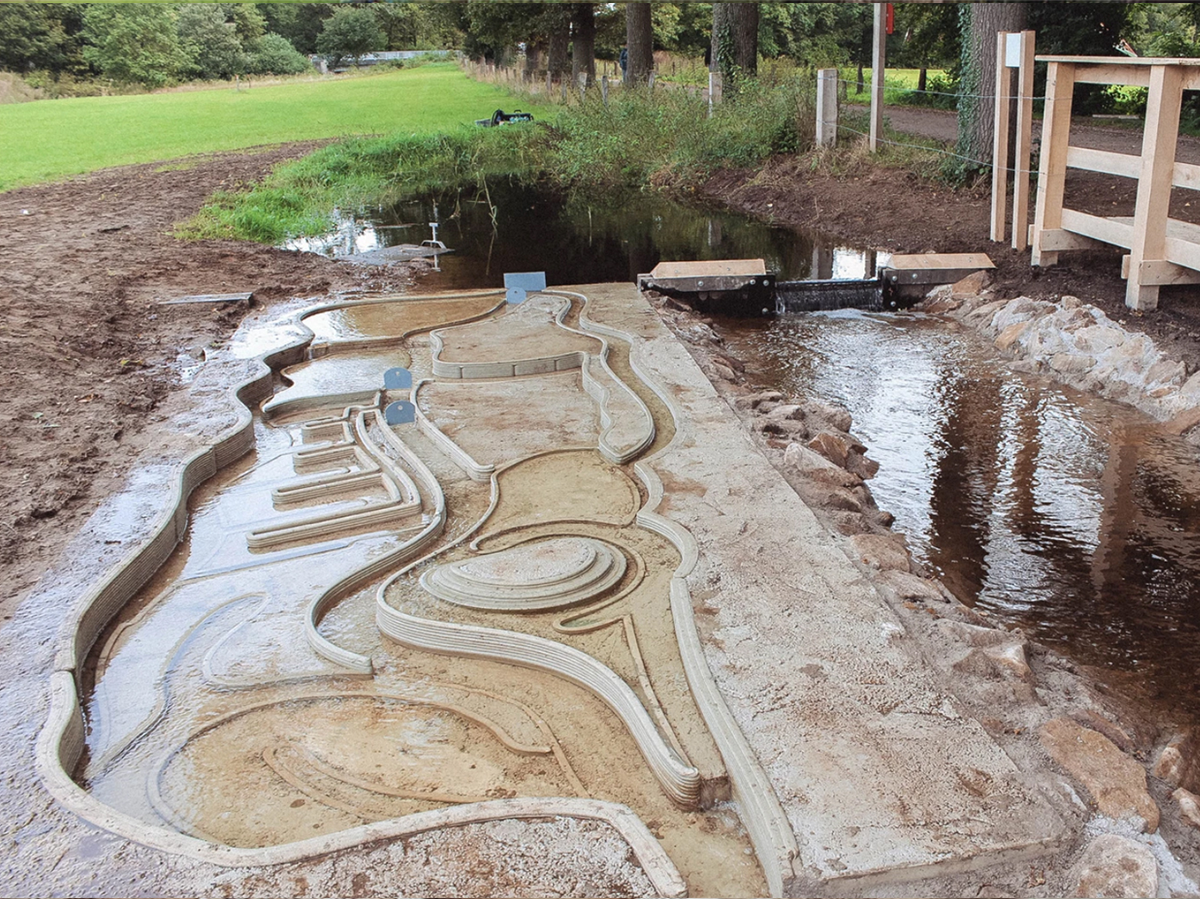 3D concrete-printed water playground installed beside a stream