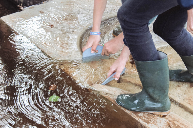 A visitor operating a removable gate to redirect water through the concrete channels
