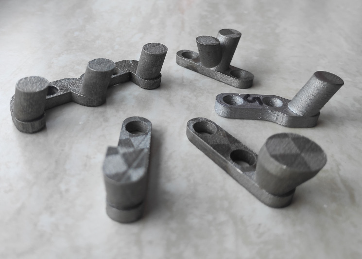 Custom metal-printed welding pushers arranged on a work surface