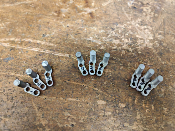 Custom 3D metal-printed welding pushers arranged on a work surface